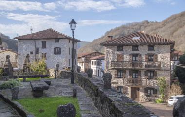 Conjunto de casas tradicionales vistas desde el exterior de la iglesia con estelas en Etxalar.