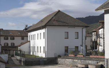 Edificio blanco de arquitectura pirenaica tradicional con tejado de pizarra en Roncal.