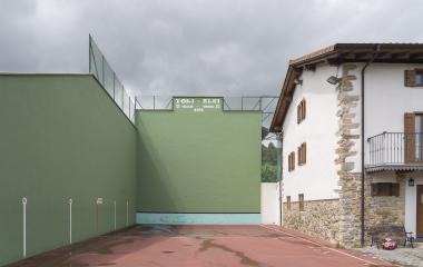 Frontón de Saigots verde y de dos paredes al lado de casa tradicional.