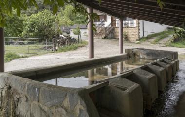 Lavadero tradicional de piedra en Sarasibar, con agua e infraestructura rural.