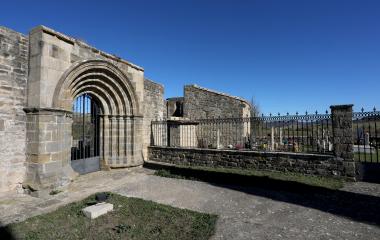 Cementerio de Unciti con arco ojival de piedra en la entrada y estructura protegida con verja moderna.