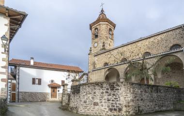 Iglesia de piedra con campanario y arquitectura románica en núcleo rural de montaña, en Anue.