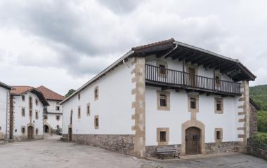 Casas tradicionales de piedra y blanco con balconadas de madera en Villanueva de Arce, Pirineo Navarro.