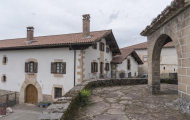 Conjunto de casas tradicionales de piedra y blanco vistas desde el exterior de la iglesia de Villanueva de Arce.