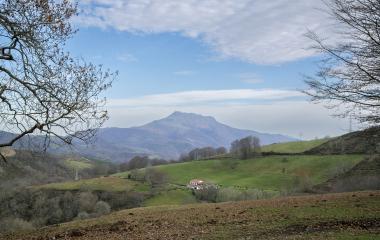 Valle de Baztan Bidasoa con caseríos dispersos, bosques y montañas al fondo.