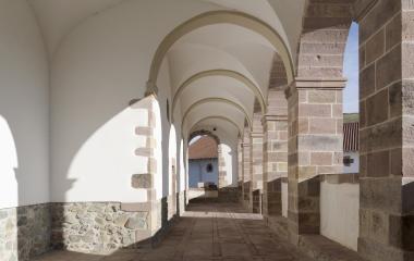 Interior de pórtico con arcos de piedra en iglesia de Ziga